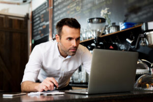 restaurant manager working on laptop, counting small business in